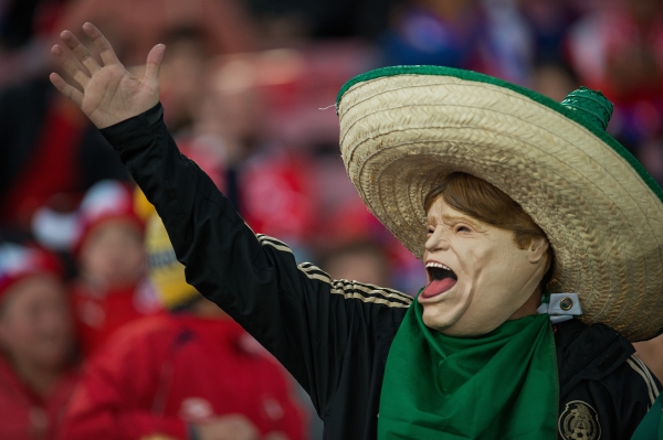 Un aficionado mexicano porta una máscara del Piojo.