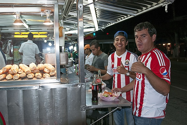 Los aficionados se deleitan con los puestos de comida.