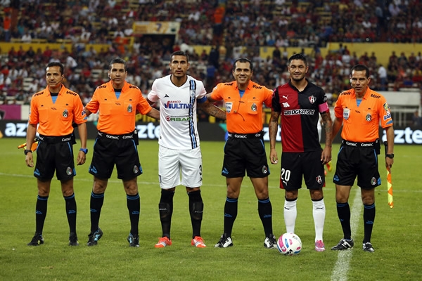 Los capitanes con la tripleta arbitral.