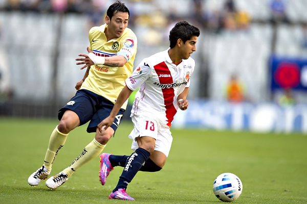 Sambueza y Zárate en disputa por el balón.