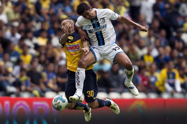 Adrián Garcí Arias disputa una pelota con el americanista, Matías Buoso.