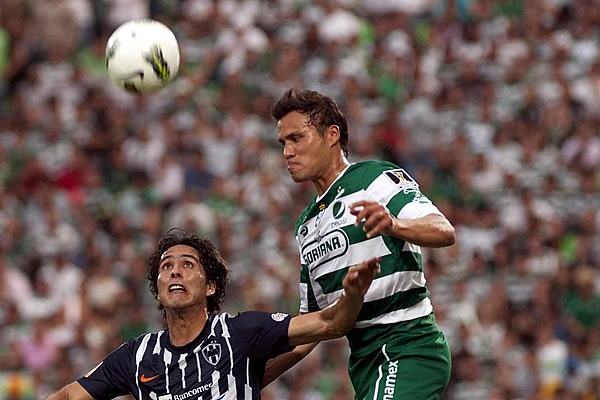 Aldo de Nigris disputa un balón aéreo con Galindo.
