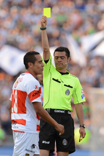 El árbitro Miguel Ángel Ayala amonestando al jugador de Jaguares.