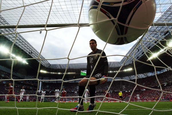 El arquero portugues, Rui Patricio observa como el balón viaja al fondo de las redes.