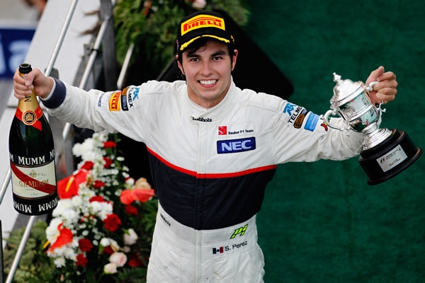 Checo con su botella y el trofeo.