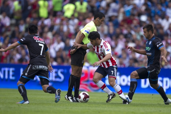 El delantero de Chivas se quita... al árbitro.