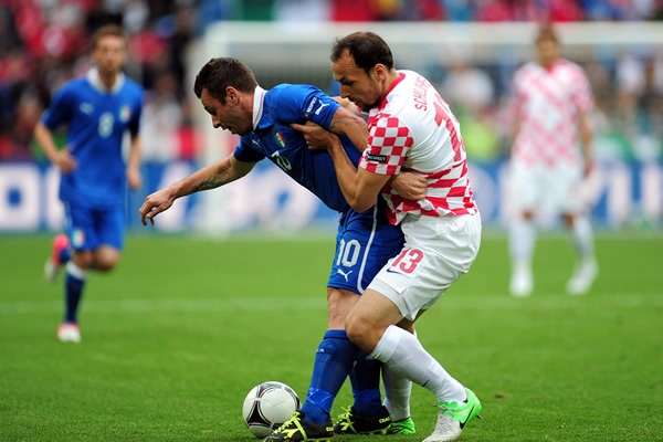 Gordon Schildenfeld intenta quitarle el balón al italiano Antonio Cassano.