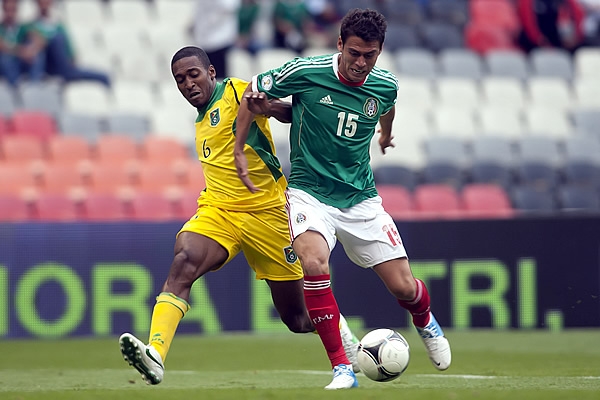 Héctor Moreno disputa la esférica con el rival.