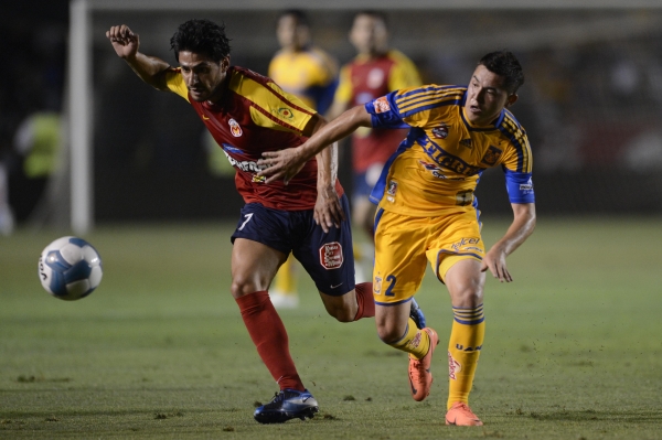 Israel Jiménez disputa la esférica con Márquez Lugo.