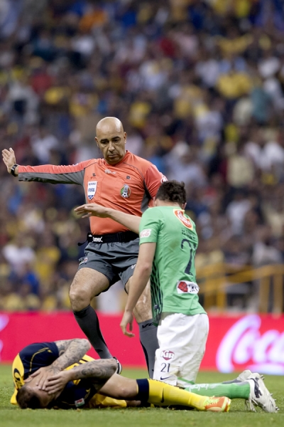 Morales, el árbitro central, señala una falta a favor del América.