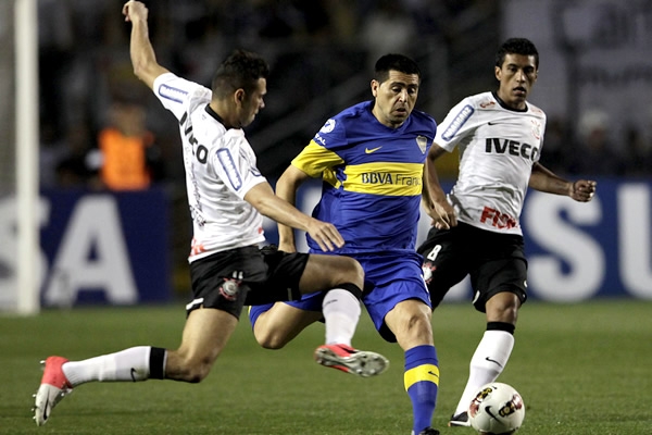 Riquelme haciendo una jugada entre dos rivales.