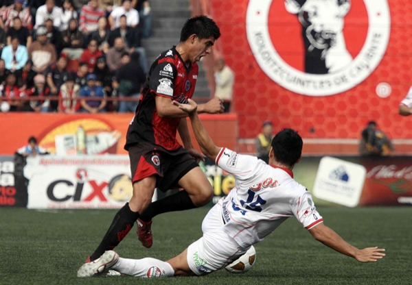 Raúl Enríquez disputando el balón.