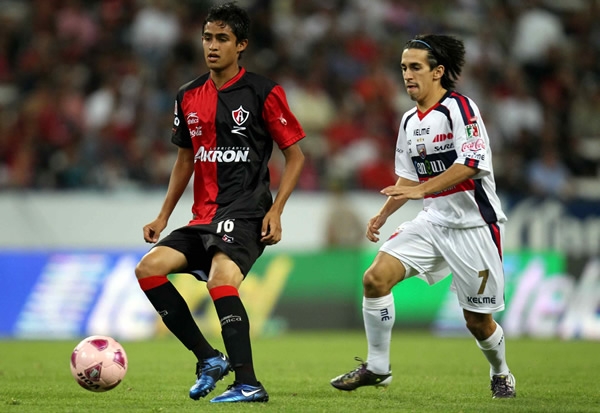 Alan Zamora protege el balón ante la mirada de Fernando Navarro.