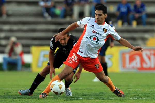 Christian Valdez protege el balón ante la mirada de su rival.