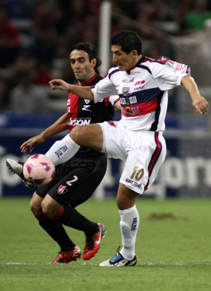 Johan Fano pelea el balón con Fabricio Fuentes.