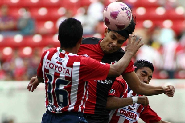Gerardo Flores, buscando el remate entre dos defensas