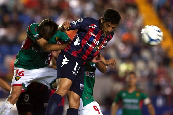 Vela y Mendieta en la disputa del balón en medio campo.
