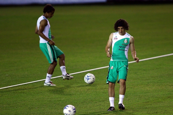 Guardado toca la pelota para calentar.
