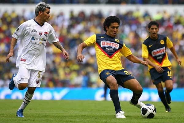 Juan Carlos Silva y José Joel González pelean por el balón
