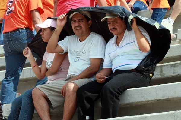 Los aficionados buscan cubrirse del astro rey