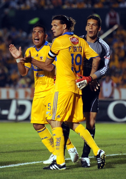 Los felinos le reclaman al árbitro luego del gol en contra.