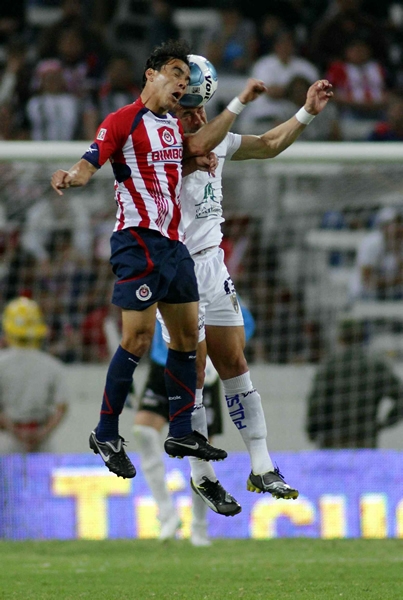 Omar Bravo disputa le pelota por los aires.
