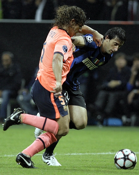 Puyol en la férrea marca ante Milito.