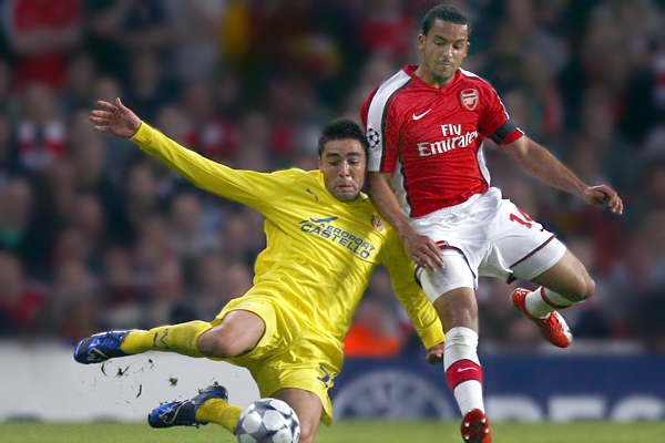 Theo Walcott se disputa el balón.