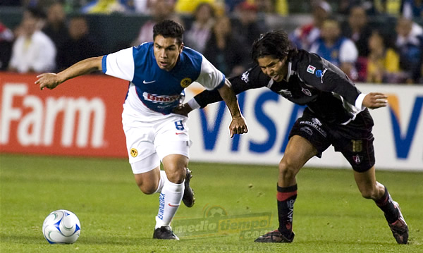 Hugo Ayala trabaja para impedir que Salvador Cabañas se lleve la bola.