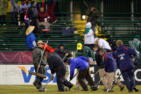 La gente del estadio sacó el agua de la cancha.