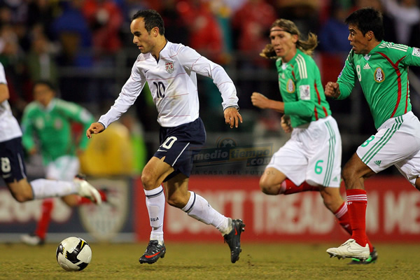 Landon Donovan es seguido por Pável y Leandro en medio campo.