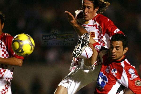 Rafael Medina apenas alcanza a sacarle el balón a Maggiolo.