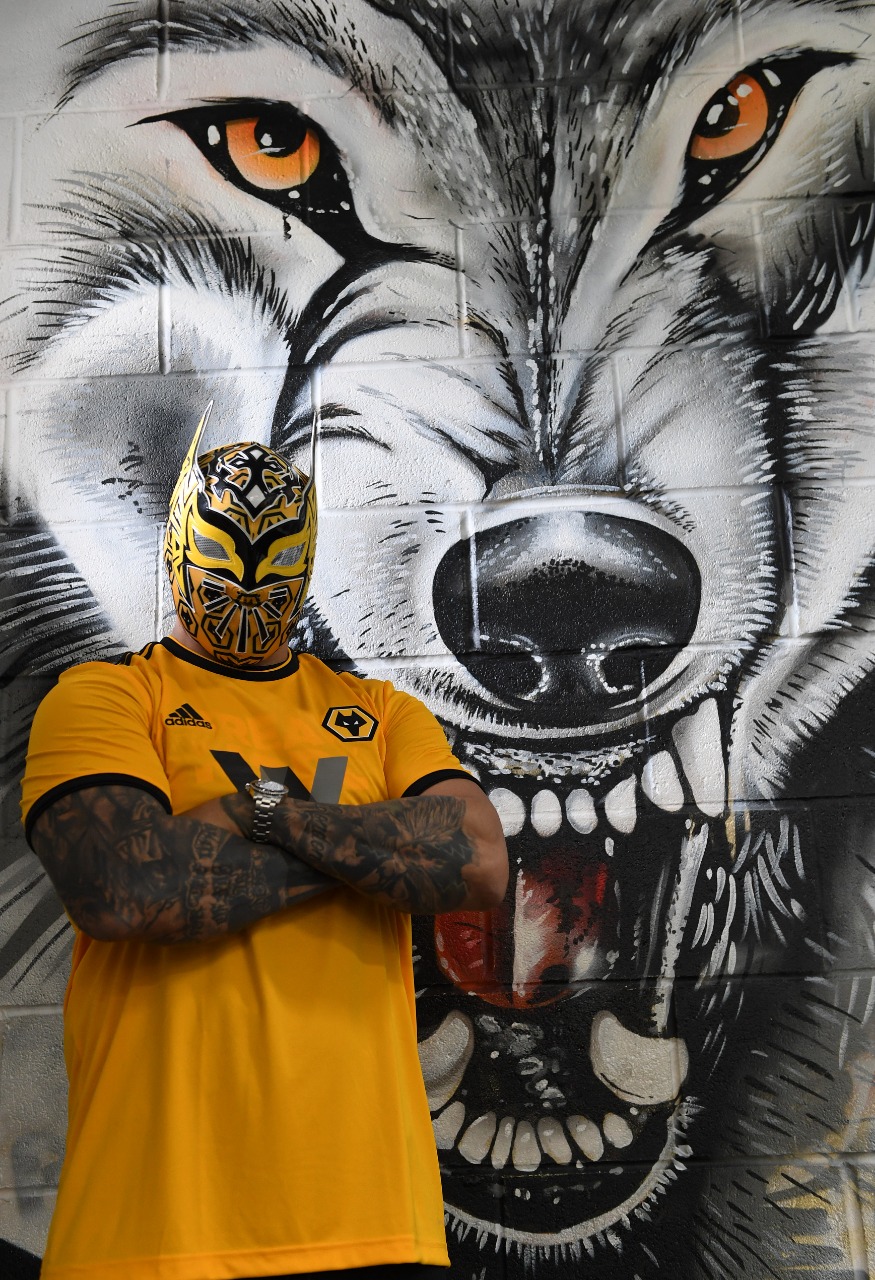 Sin Cara posa frente a la imagen del lobo de Wolverhampton. (Foto: @SinCaraWWE)