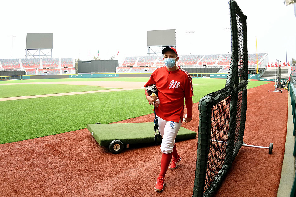 El pitcher Carlos Vázquez regresa a la caseta después de haber realizado algunos ejercicios en el campo