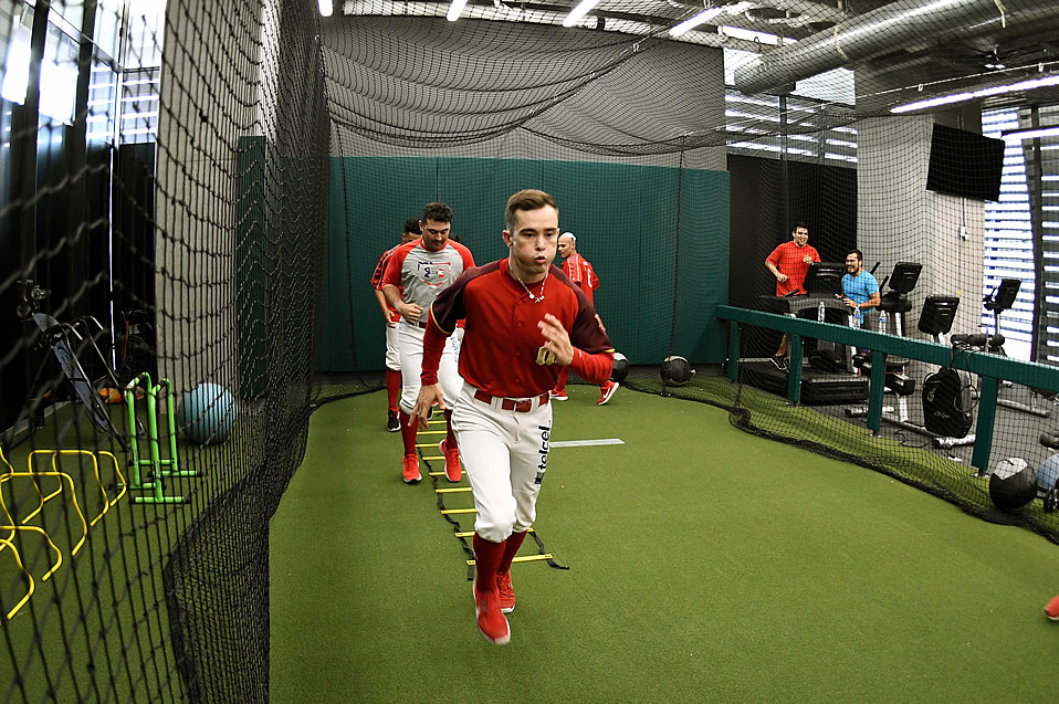 En primer plano está Carlos Figueroa, haciendo sprints dentro de la jaula de bateo