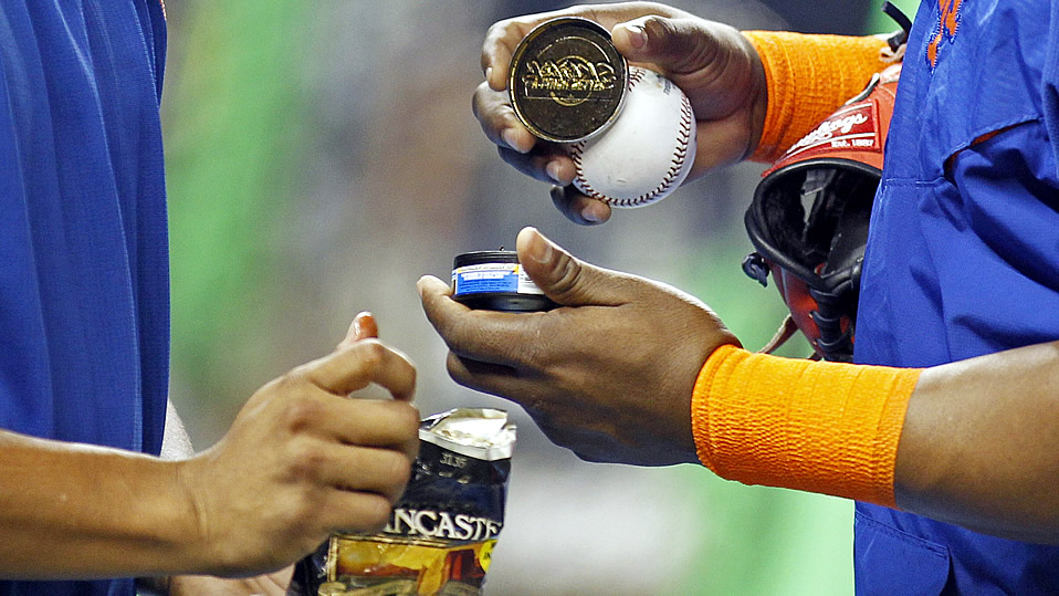 Peloteros sacan tabaco para mascar de su envase. Foto: AP