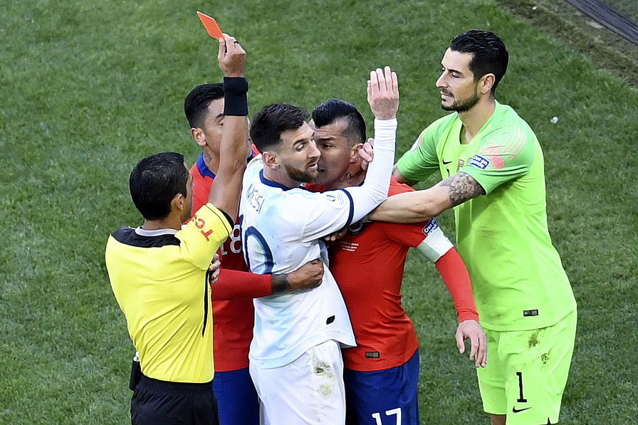 Momento en que el central expulsa a Messi y Medel. (Foto: AFP)