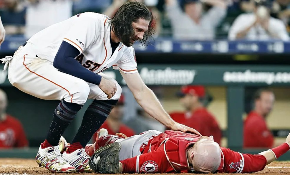 Luego del choque en home, Marisnick revisa si Lucroy se encuentra estable.