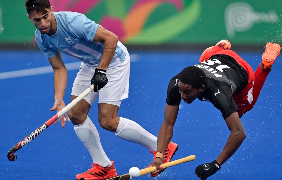 El argentino Martin Ignacio Ferreiro (izq.) Y el trinitense Mickell Pierre en hockey masculino, Lima 2019. (Foto: Luis ROBAYO / AFP)