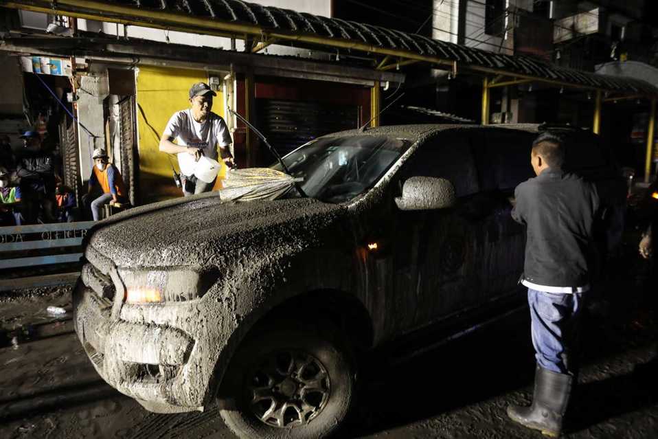 Los pobladores tuvieron que lavar sus autos para retirar la cenizas del volcán. FOTO: EFE