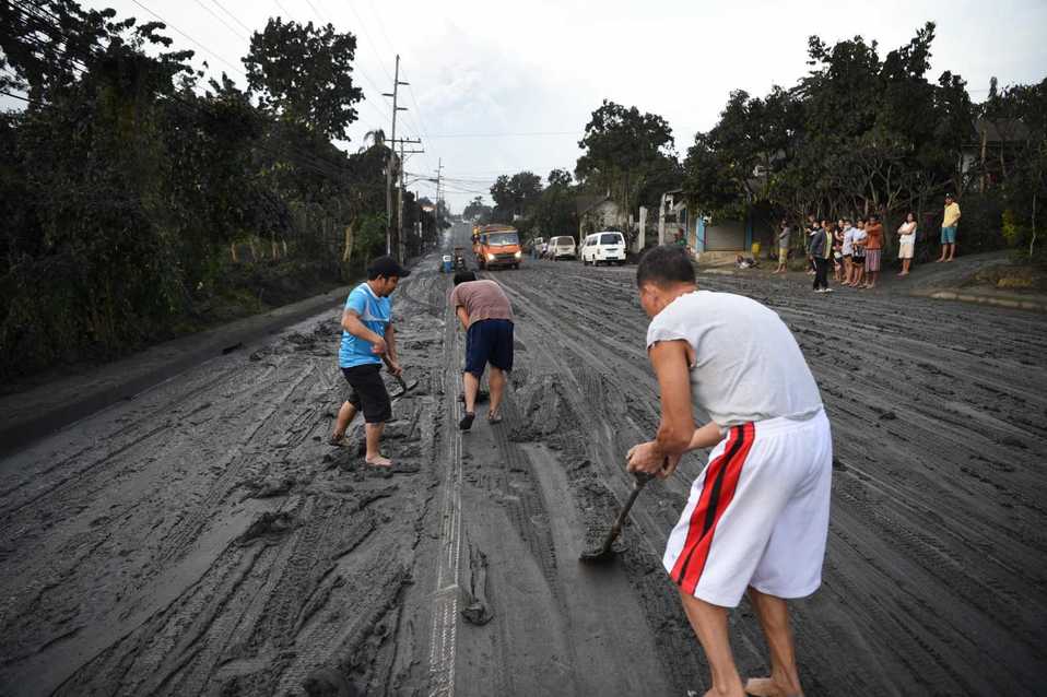 Tras la erupción del volcán Taal los filipinos se dieron a la tarea de iniciar la limpieza de calles. FOTO: AFP