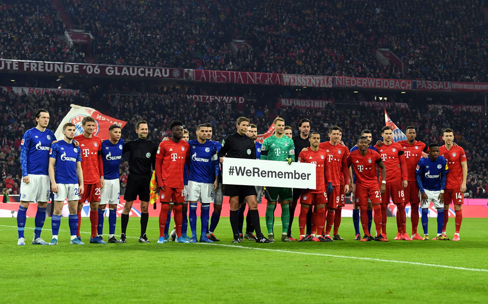 Jugadores del Bayern y Schalke 04 sostienen un cartel que dice "Recordamos", con motivo de la liberación del campo de concentración de Auschwitz. (Fot