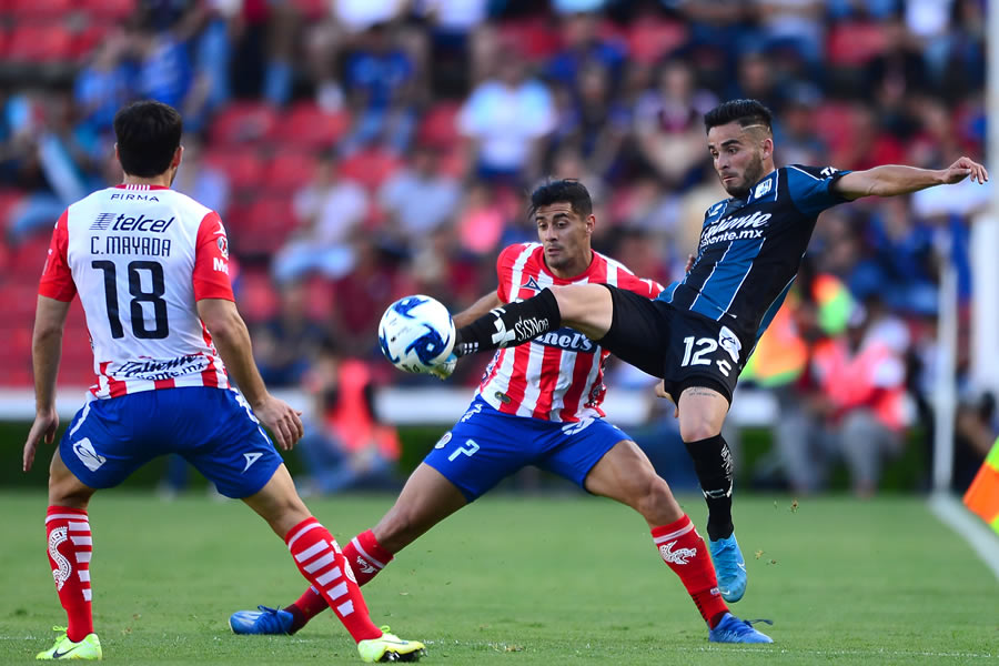 Areli Hernández toca el esférico ante la presión de un rojiblanco. FOTO: Mexsport.
