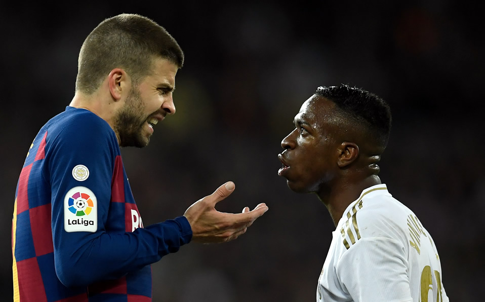 Piqué habla con el brasileño Vinícius Junior durante el Clásico. (Foto: AFP)