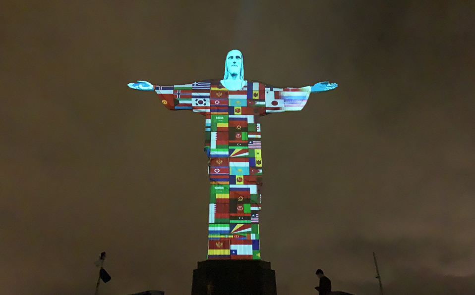 Las banderas de los países afectados por el coronavirus se proyectan en la estatua del Cristo Redentor. (Foto: AFP)