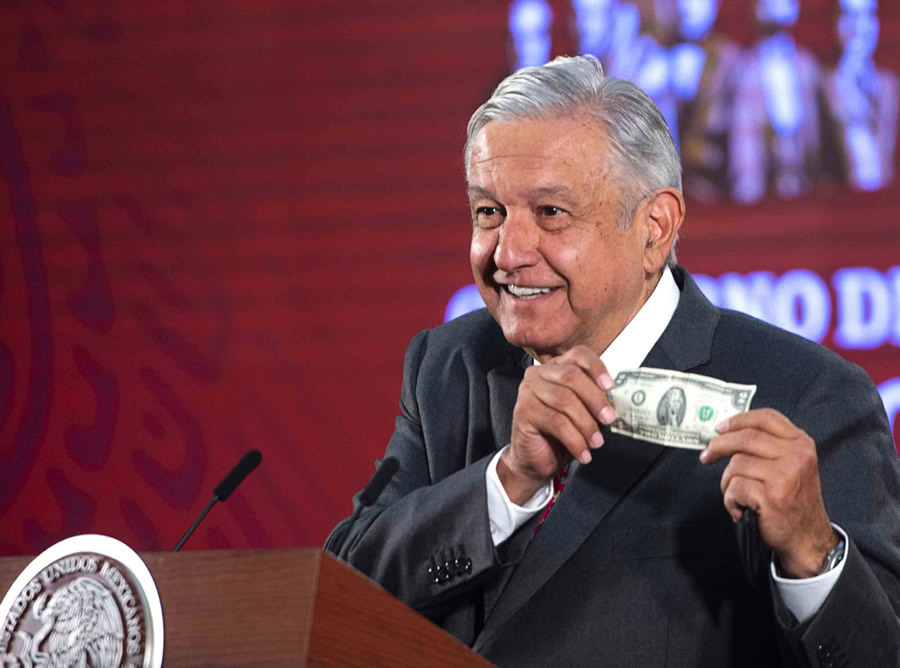 El Presidente de México muestra un dólar en una conferencia de prensa. FOTO: AFP.