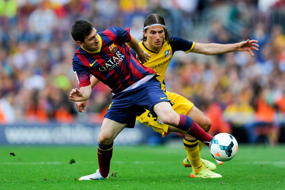 Lionel Messi y Filipe Luis disputando un balón.