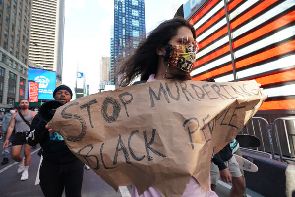 "Dejen de asesinar a gente negra", es el reclamo de esta persona en Times Square.