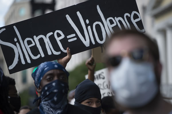 "Silencio = Violencia" reza esta pancarta en una marcha en Chicago.
