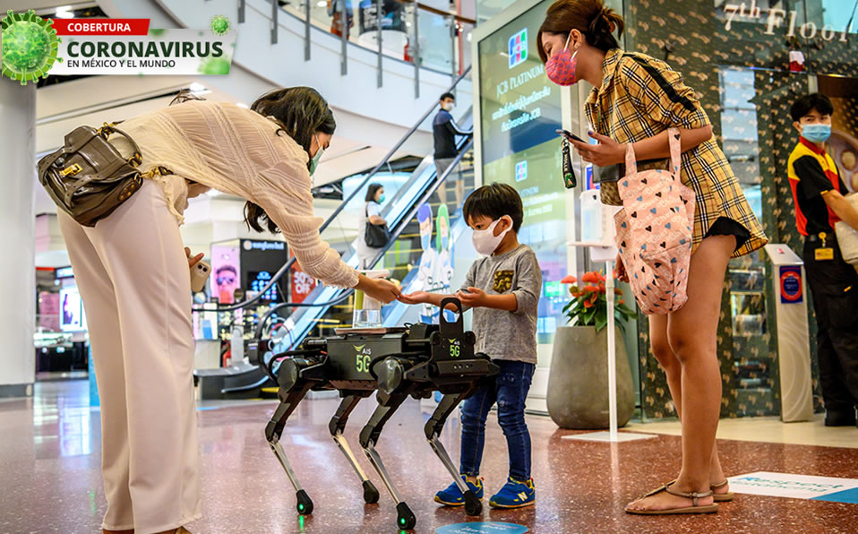 K9 ayuda a sanitizar las manos de los usuarios de un centro comercial (AFP)